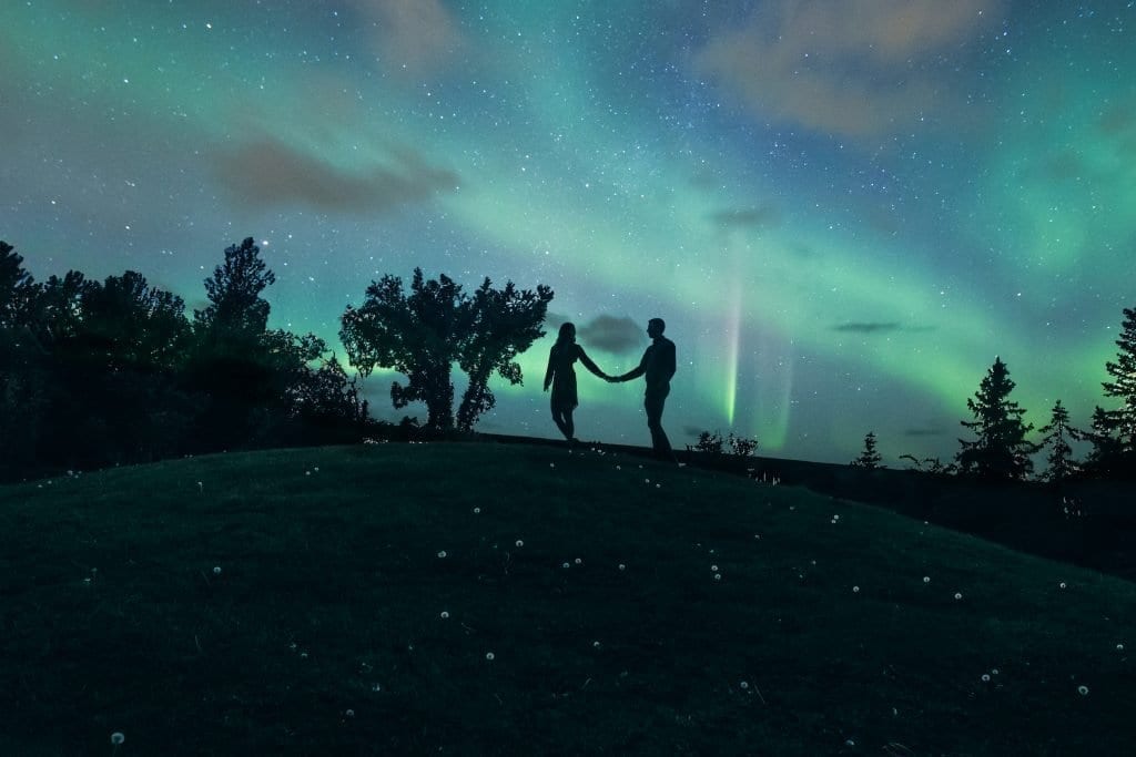 Night time photo of engaged couple in Iceland with the northern lights