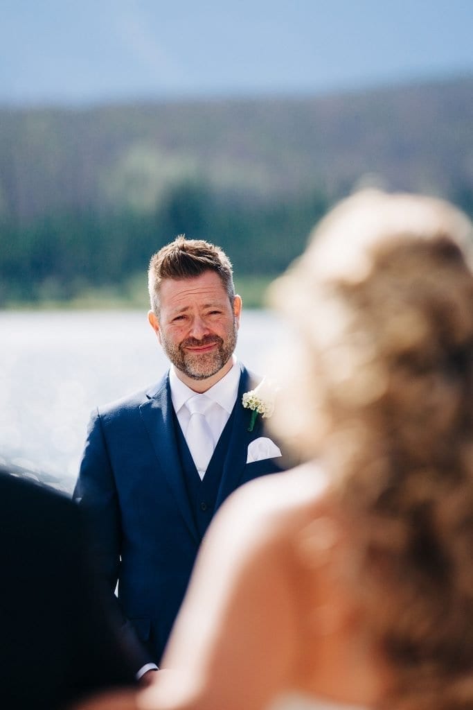 groom watching her bride walk to him with her dad