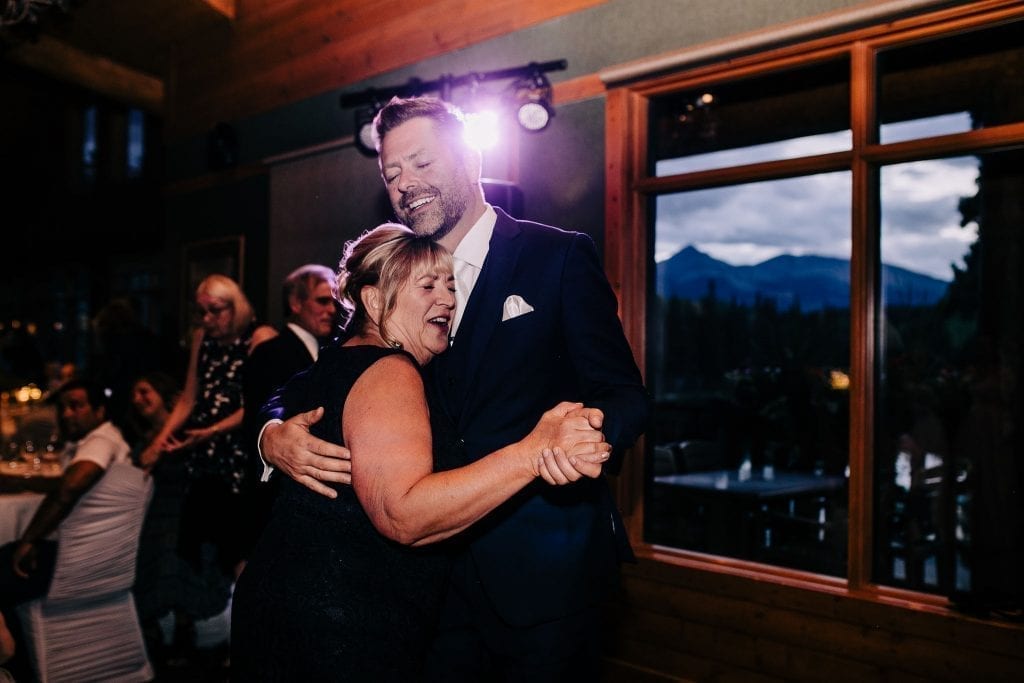 Happy mother of the groom dancing with his son photos